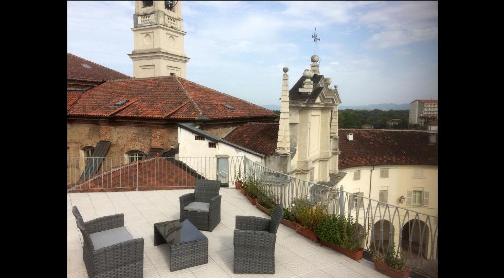 un gruppo di sedie seduti su un balcone di fronte a un edificio di La Terrazza sulla Venaria Reale a Venaria Reale