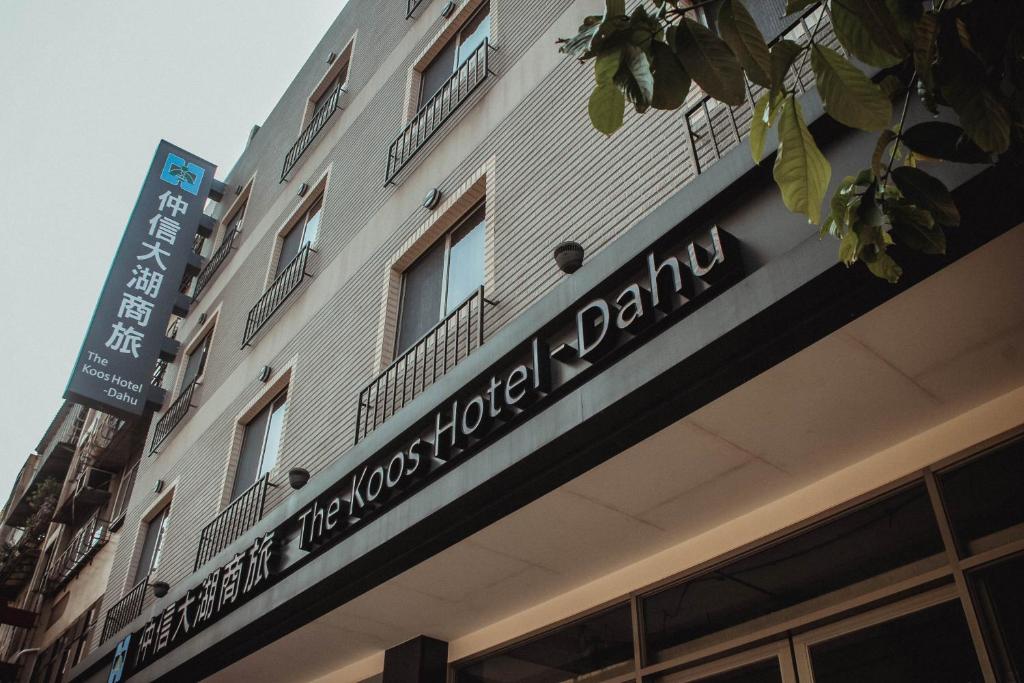 a building with a sign on the side of it at The Koos Hotel Dahu in Taipei