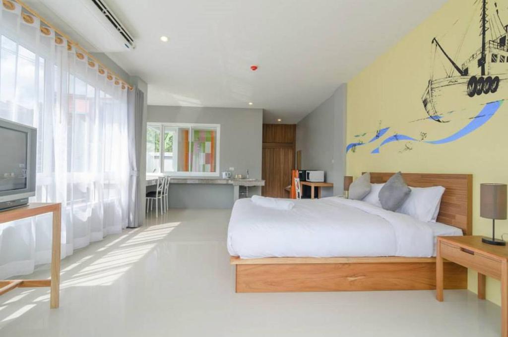 1 dormitorio con 1 cama y TV. en Ao Nang Miti Resort, en Ao Nang Beach