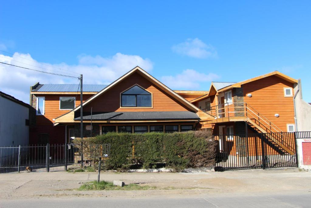 uma casa de madeira com uma cerca em frente em Hostal Fernando de Magalhaes em Punta Arenas