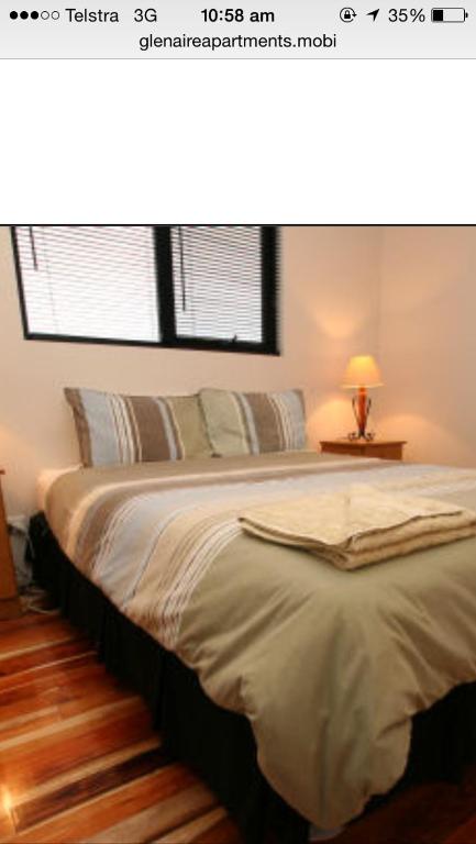 a bedroom with a large bed with a window at Glenaire apartments at Meredith in Strahan