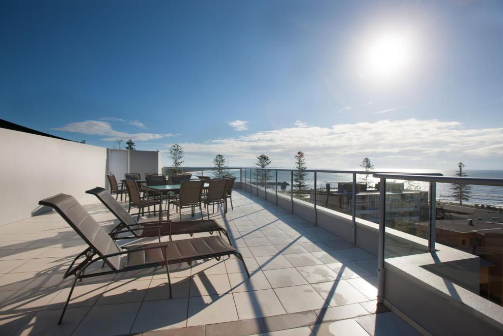 un balcón con sillas y una mesa en el techo en Ki-ea Apartments, en Port Macquarie