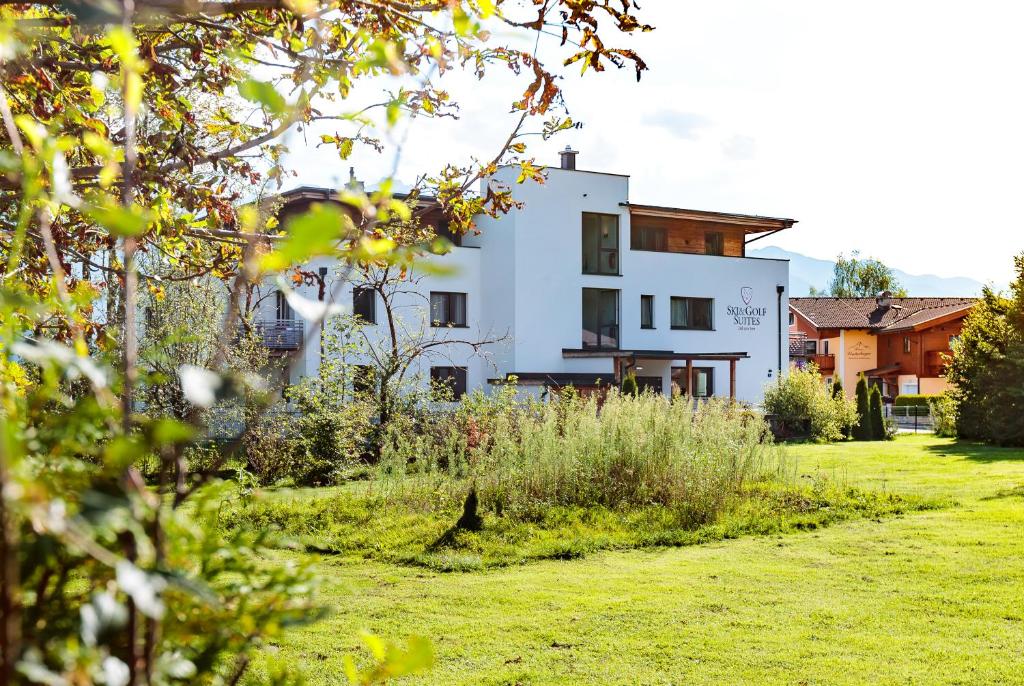 una casa blanca con un patio delante en Ski & Golf Suites Zell am See by Alpin Rentals en Zell am See