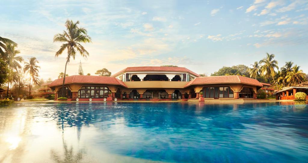 un resort con piscina di fronte a un edificio di Taj Fort Aguada Resort & Spa, Goa a Candolim