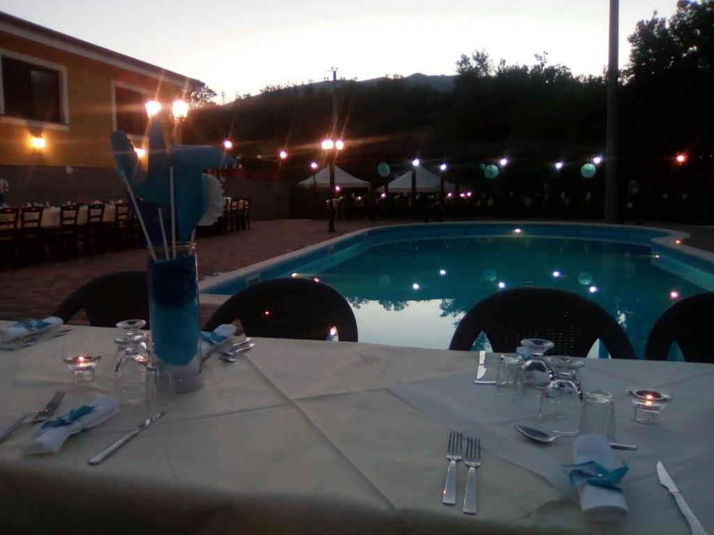 una mesa preparada para una comida frente a una piscina en Agriturismo La Madonnina, en Castrovillari