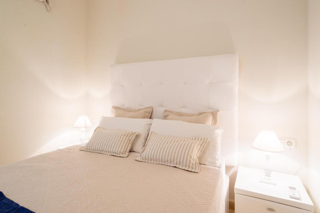 A bed or beds in a room at MalagaSuite Front Beach Malagueta