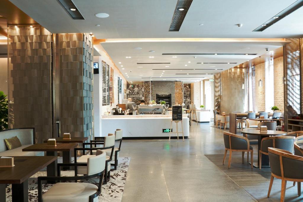 a restaurant with tables and chairs and a counter at Artyzen Habitat Dongzhimen Beijing in Beijing