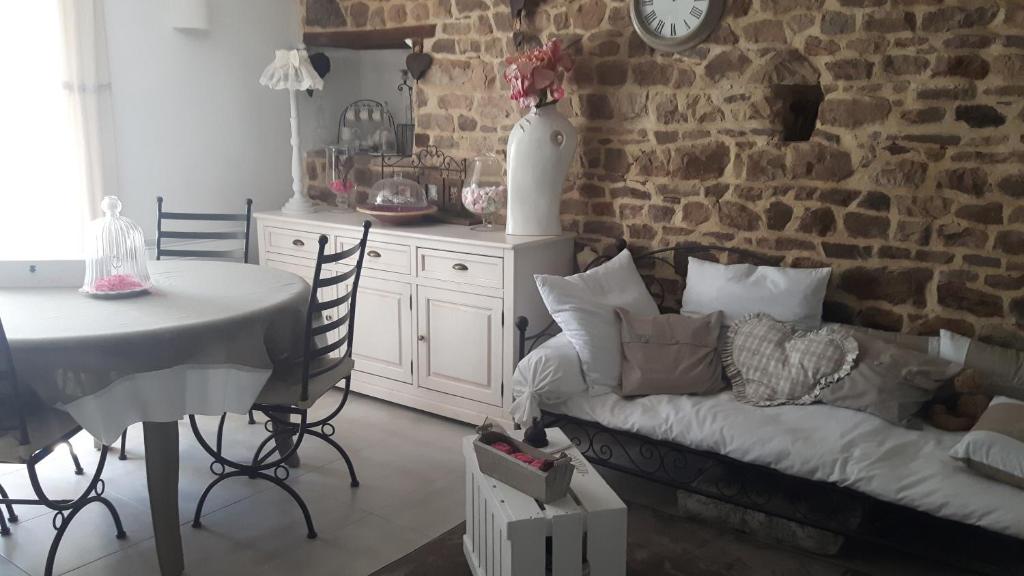 a living room with a couch and a table and a brick wall at Chambres d'Hôtes La Clef des Champs in Montpinchon