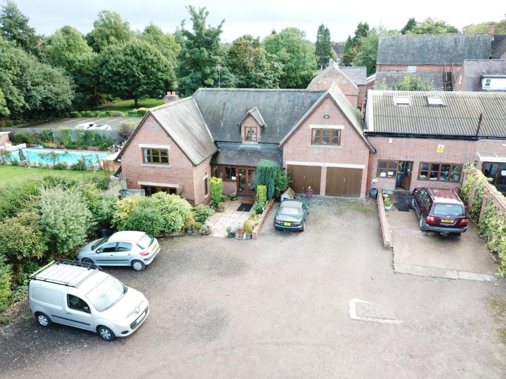 an aerial view of a house with cars parked in a driveway at Castle Farmhouse Bed and Breakfast in Leicester