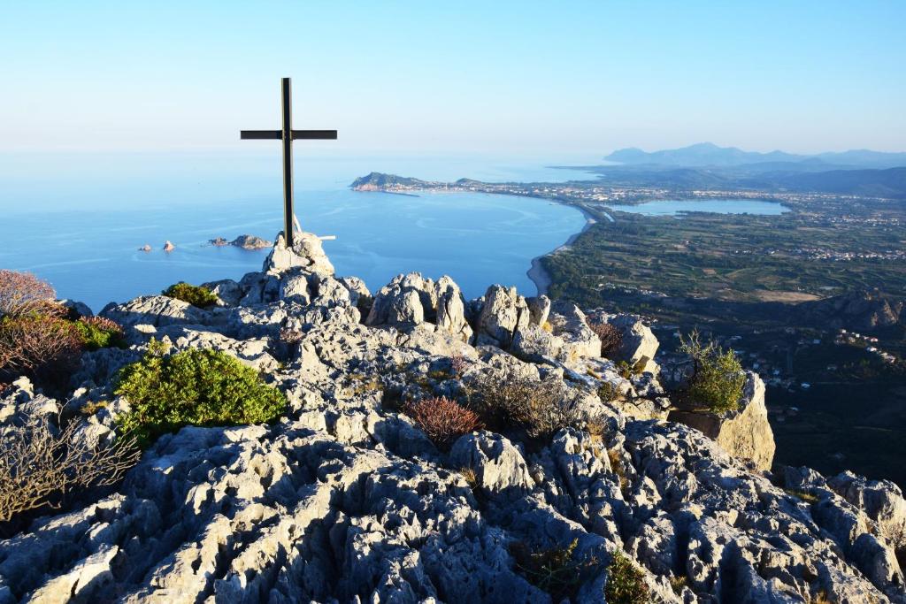 a cross on top of a mountain with a view at Apartment Verde in Santa Maria Navarrese