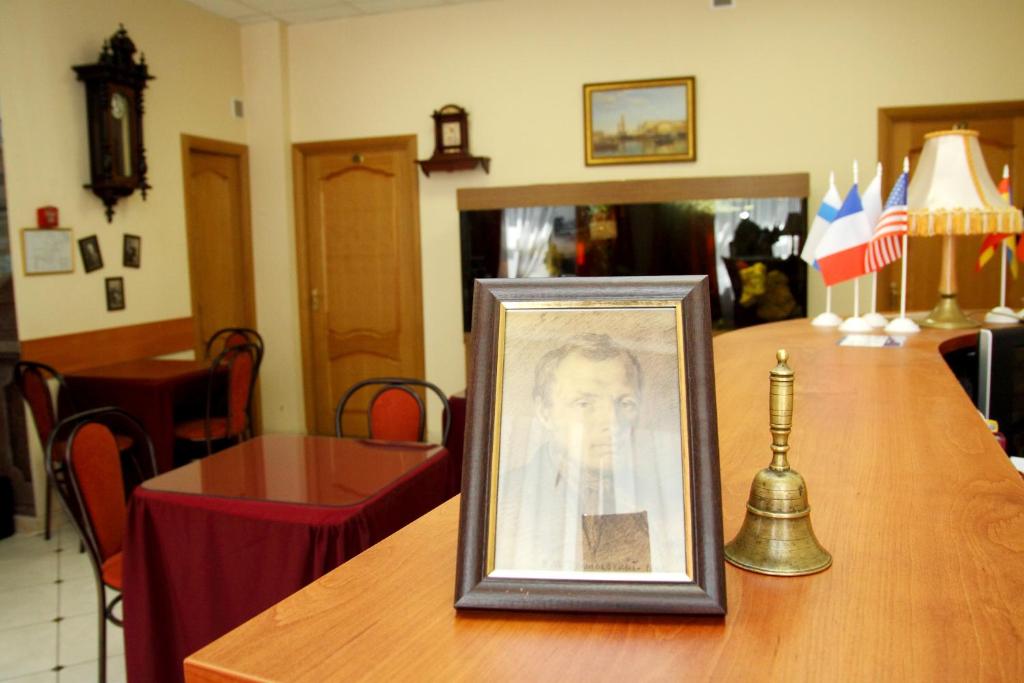 ein gerahmtes Bild einer Frau auf einem Tisch in der Unterkunft Dom Dostoevskogo in Sankt Petersburg