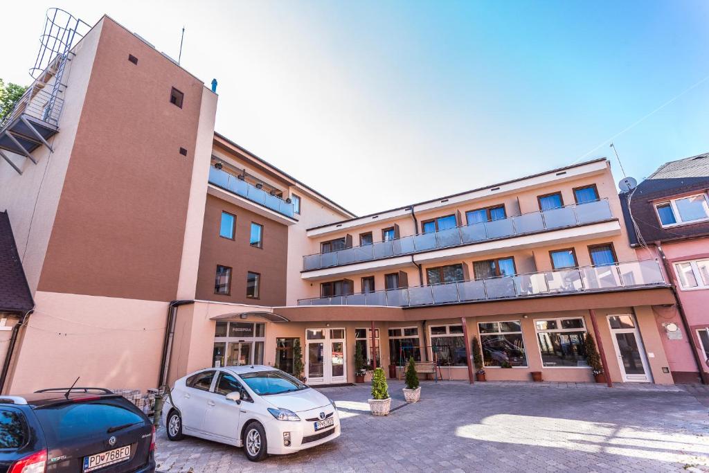 a car parked in a parking lot in front of a building at Garni Hotel Anne-Mary in Piešťany