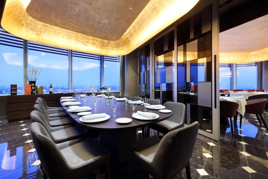 a dining room with a long table and chairs at Eurostars Torre Sevilla in Seville