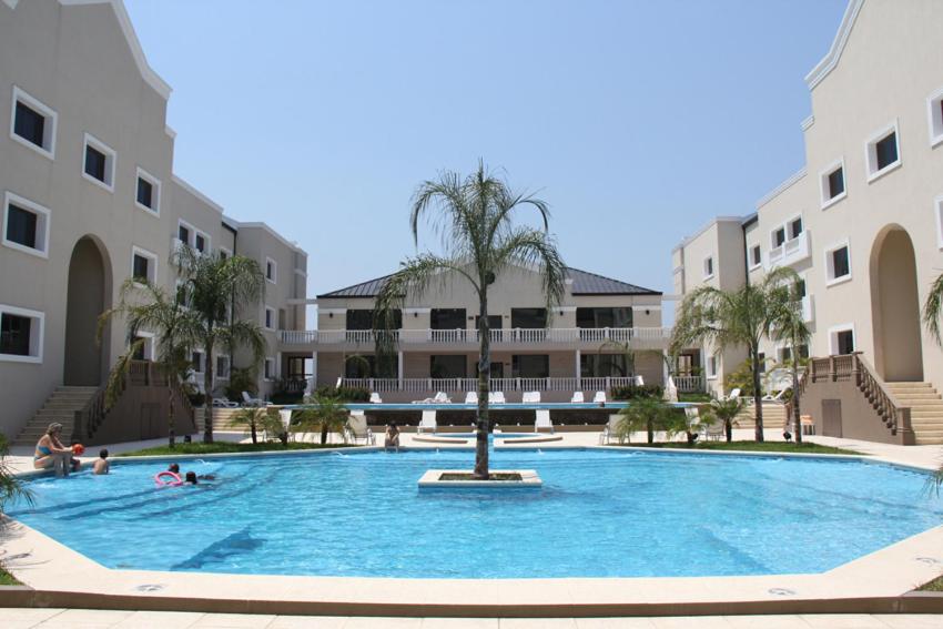 una gran piscina con una palmera frente a un edificio en Howard Johnson Hotel & Casino en Formosa