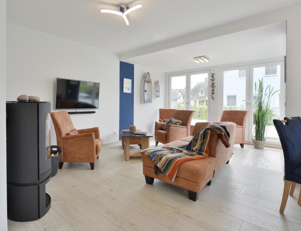 a living room with a couch and chairs and a tv at Ferienhaus Ausguck in Breege