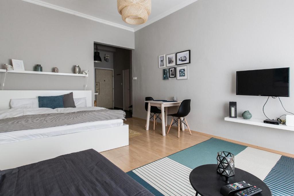 ブダペストにあるRevay 2 Apartmentの白いベッドルーム(ベッド1台、テーブル付)
