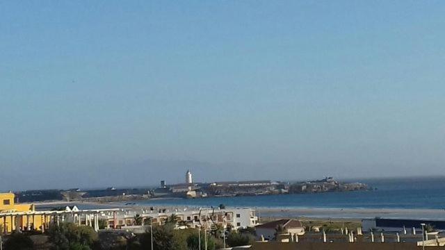 タリファにあるLa Doradaの灯台付きの海とビーチの景色