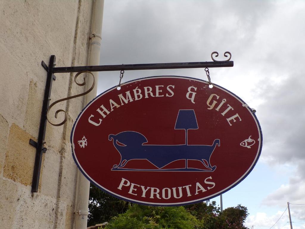a red sign hanging on the side of a building at Chambres Peyroutas "Amélie" à Vignonet St Emilion in Vignonet