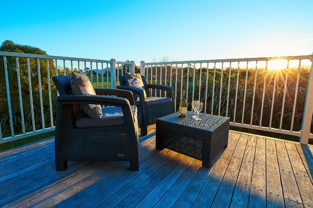 2 chaises et une table sur une terrasse dans l'établissement Kakatu Retreat, à Kaikoura