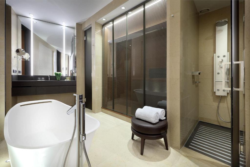 a bathroom with a tub and a toilet and a sink at Eurostars Torre Sevilla in Seville