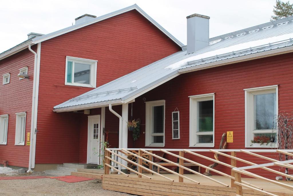 a red house with a porch and a white roof at Kairalan Kievari in Salla