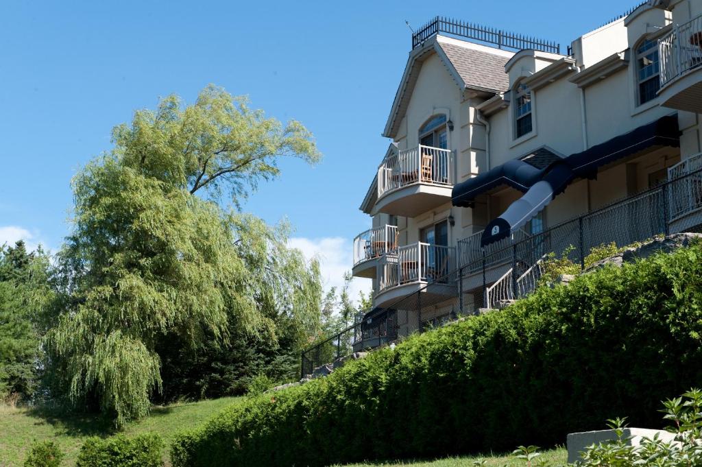 a building with balconies on the side of it at Hotel St-Sauveur in Saint-Sauveur-des-Monts