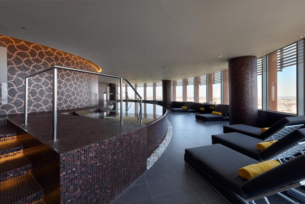 a living room with couches and chairs in a building at Eurostars Torre Sevilla in Seville
