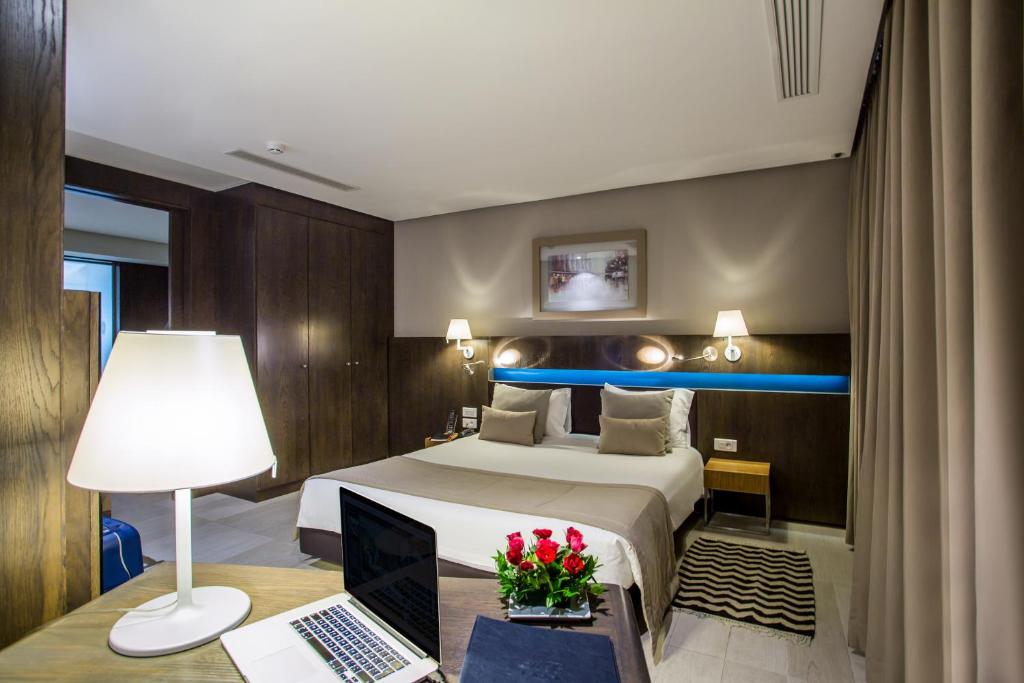 Habitación de hotel con cama y escritorio con ordenador portátil en Hôtel Belvédère Fourati en Túnez