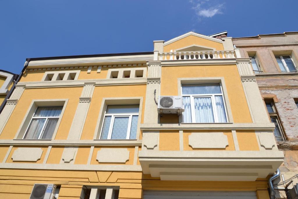 プロブディフにあるGuest Rooms Filipopolの黄色の建物(窓、バルコニー付)