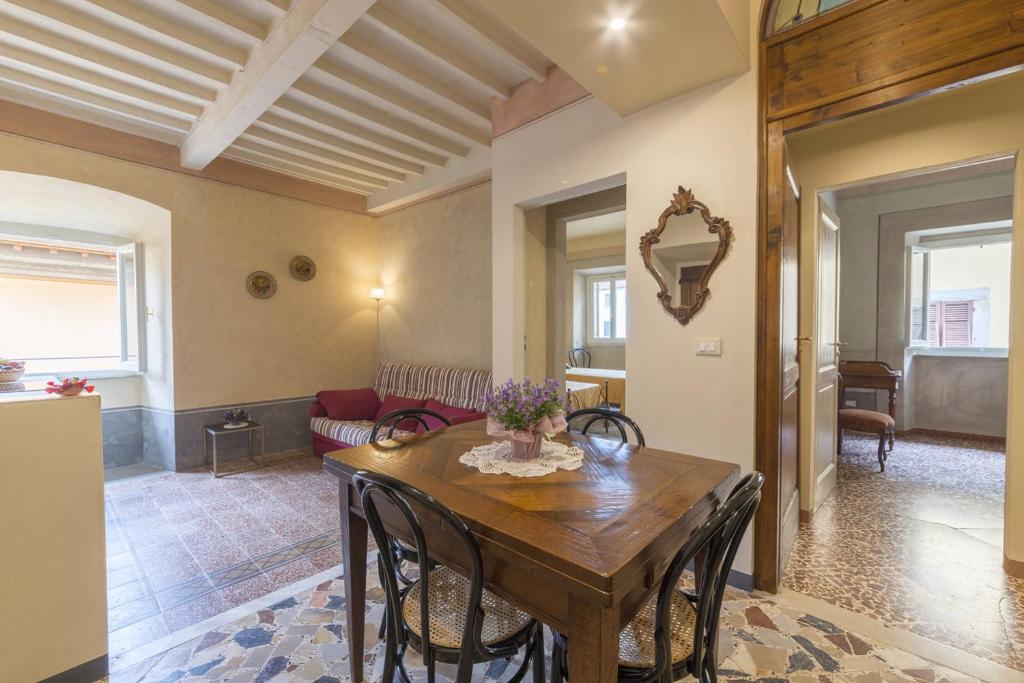 uma sala de estar com uma mesa de madeira e cadeiras em I Bei Ricordi - Historic Centre Apartment 6 em Arezzo