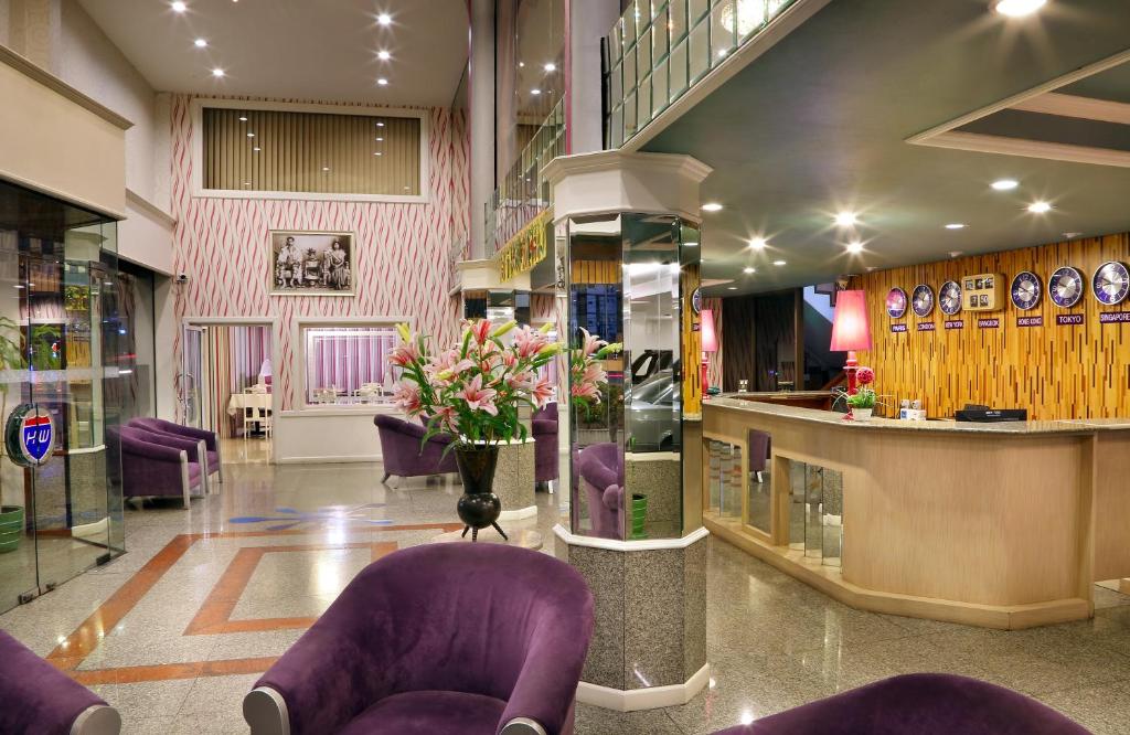 a lobby with purple chairs and a bar in a store at Highway Hotel in Chiang Mai