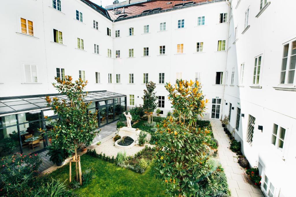 an apartment courtyard with trees and a fountain at myNext - Johannesgasse Apartments in Vienna