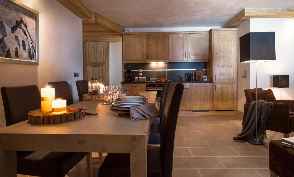 a kitchen and dining room with a table and chairs at CGH Résidences & Spas l'Orée des Neiges in Landry