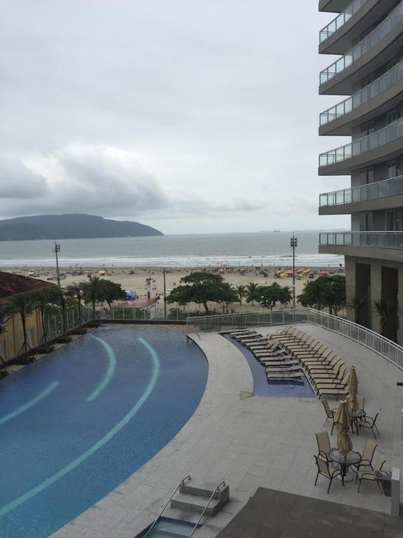 een zwembad met uitzicht op het strand bij Loft com vista para o mar in Santos