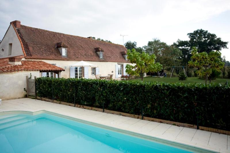 a house with a swimming pool in front of a fence at La Tuilerie du Paligny in Tallud-Sainte-Gemme