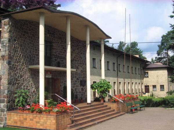 un edificio con escaleras y flores delante en Zajazd Turystyczny HETMAN, en Augustów