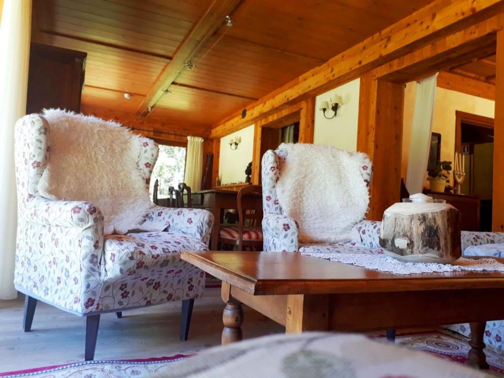 two chairs and a table in a living room at Le Rocher Hotel in Champoluc