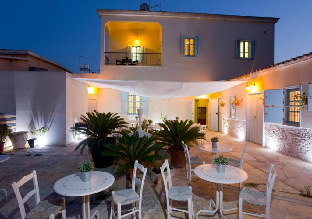 un patio con mesas y sillas frente a un edificio en Shongas Inn en Dherinia