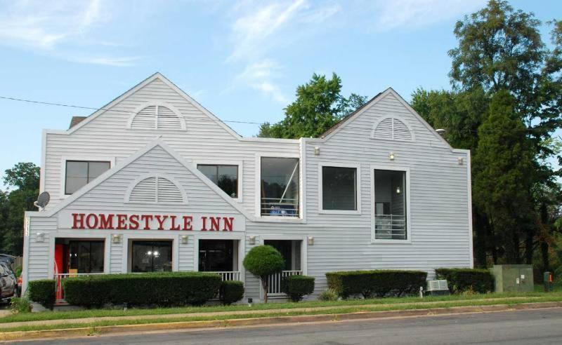 Ein weißes Haus mit einem Schild, das Homeestyle Inn liest in der Unterkunft Home Style Inn in Manassas
