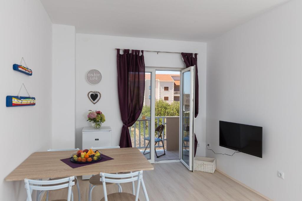 a kitchen and dining room with a table and a television at Apartman Rokolj in Cavtat