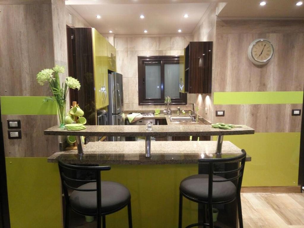 een badkamer met een wastafel en een aanrecht met krukken bij Luxury Mamoura Alexandria Apartment in Alexandrië