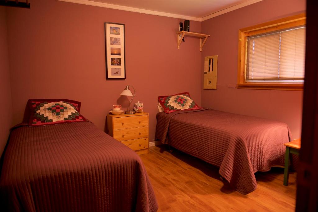 a bedroom with two beds and a window at Bluenose Bed & Breakfast in Snow Lake