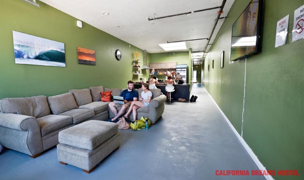 a group of people sitting on couches in a room at California Dreams Hostel - Pacific Beach in San Diego