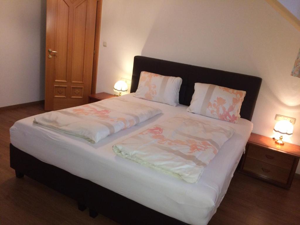 ein großes Bett in einem Zimmer mit zwei Nachttischen in der Unterkunft Landhaus Scherling in Keutschach am See