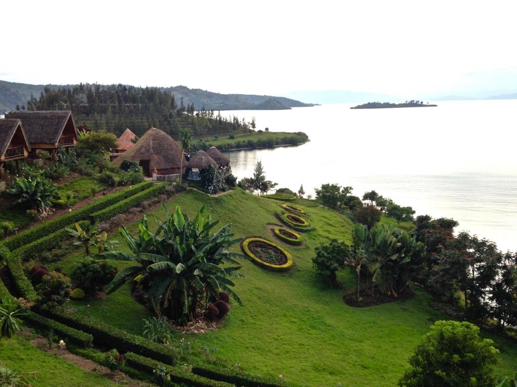 an aerial view of a house on a hill next to the water at Rwiza Village in Gitesi