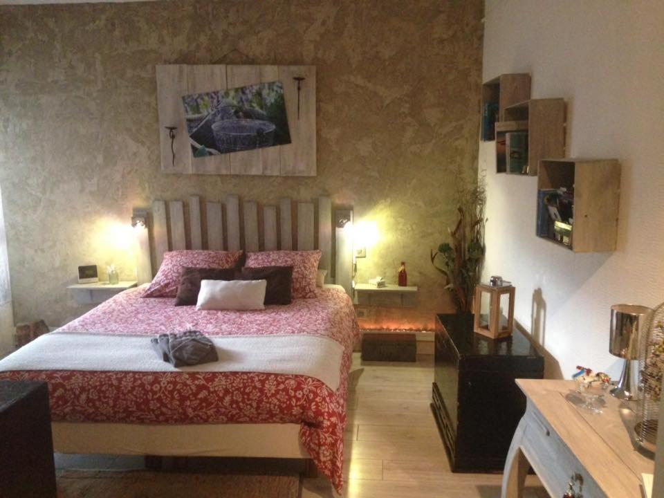 een slaapkamer met een groot bed met roze lakens bij Bienvenue Chez Nous in Clouange