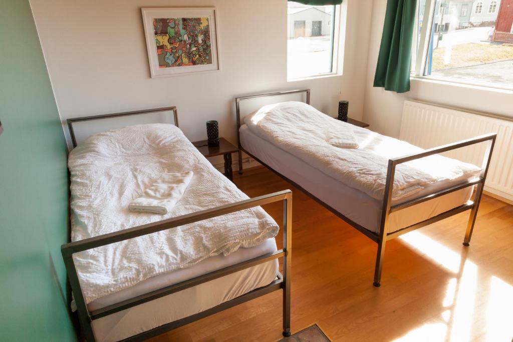 a bedroom with two beds and a window at Sjávarborg in Stykkishólmur