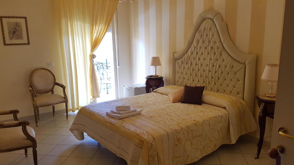 1 dormitorio con 1 cama grande y cabecero grande en B&B TORRE DEI SARACENI, en Marina di Gioiosa Ionica