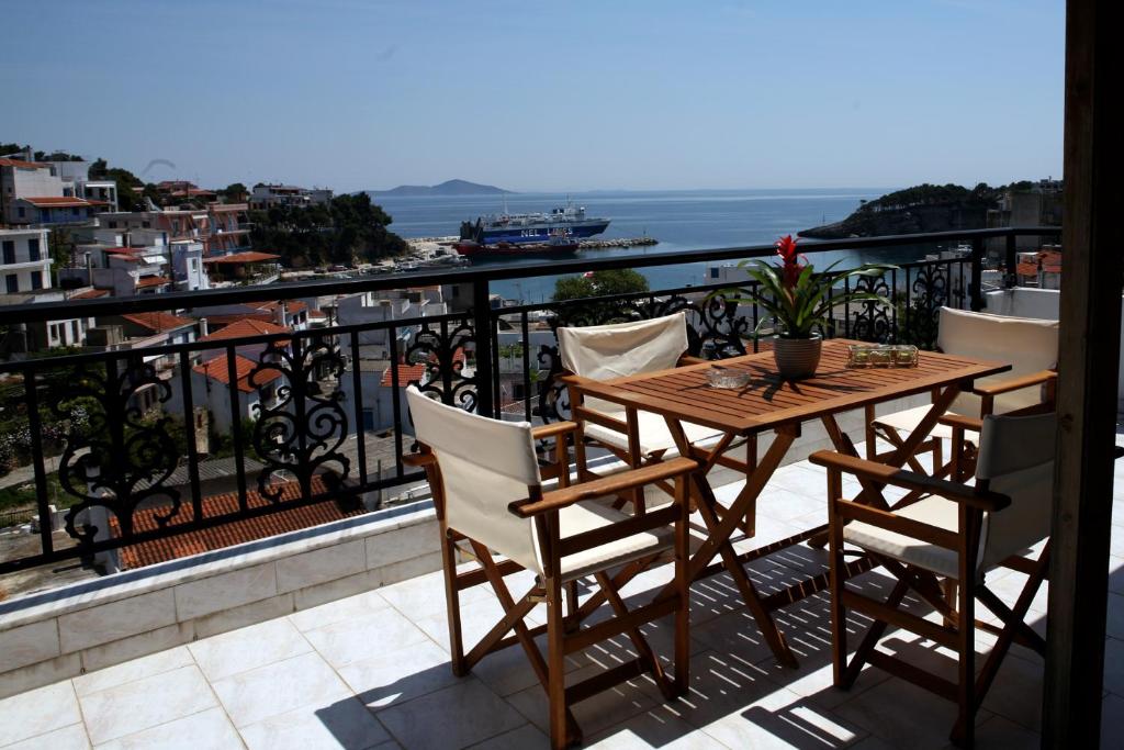 una mesa y sillas en un balcón con vistas al océano en Theodora en Patitiri