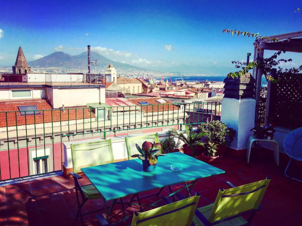 a table and chairs on a balcony with a view at Mansarda Bellini in Naples